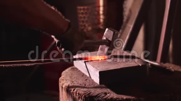 铁匠用大锤在铁砧上缓慢地敲击铁棒视频的预览图