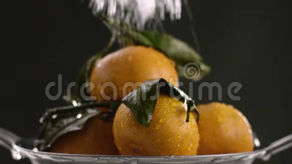 在橘子上注入了强烈的水流在视频的末尾水停止了黑色的背景视频的预览图