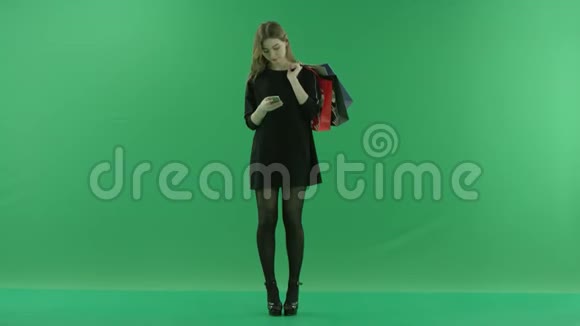 适合年轻女性在智能手机上上网背后有包彩色钥匙绿色背景视频的预览图