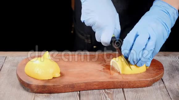 厨师在手套上切柠檬在木切割板上餐厅的食物咕咕叫慢动作高清高清视频的预览图