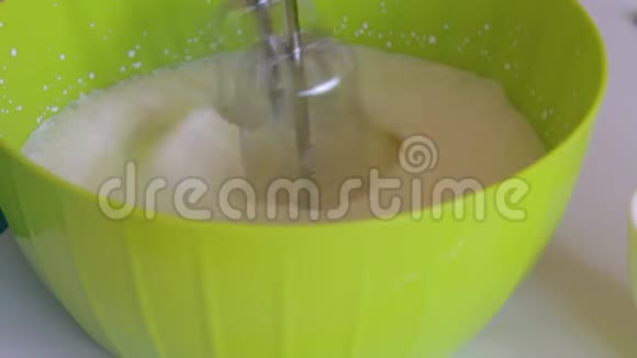 一个女人用搅拌器搅拌奶油旁边的其他食材做甜点糖和草莓视频的预览图