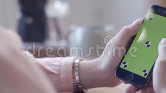 年轻的女人有漂亮的指甲手里拿着iPhone在彩色钥匙绿色屏幕上打字库存数据视频的预览图
