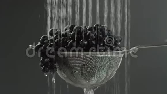 在视频中我们看到葡萄在筛子中水从顶部落在视频中间的单个射流中水掉下来视频的预览图