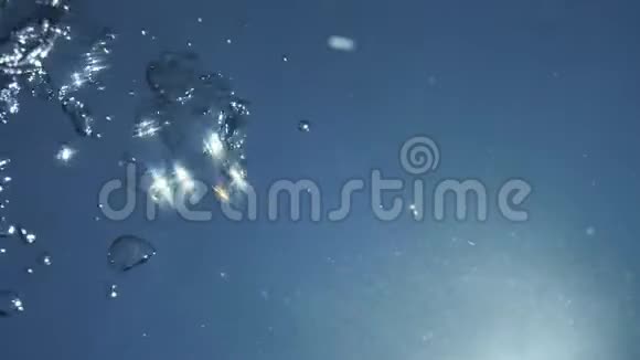 在水下自然阳光照射下空气中闪耀着闪烁流动的气泡视频的预览图