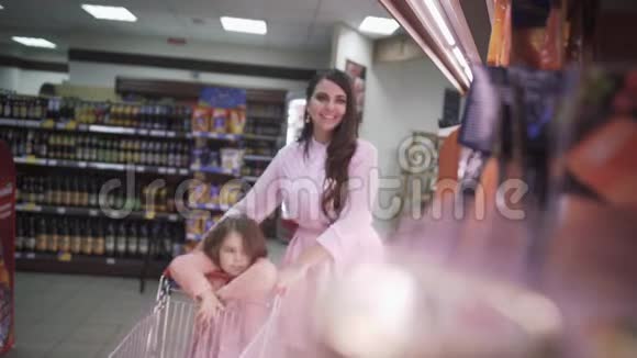 可爱的小女儿帮妈妈在超市购物视频的预览图
