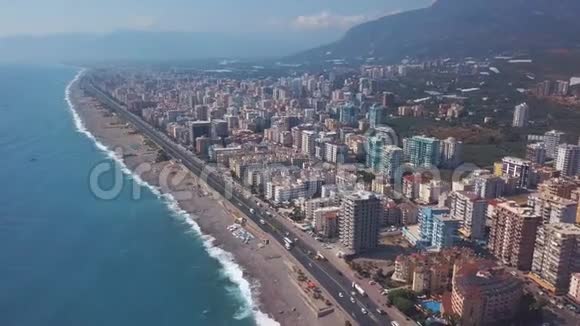 鸟瞰美丽的海岸线现代化的酒店和土耳其阿拉尼亚的海水在炎热的蓝天衬托下视频的预览图