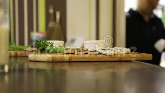 咖啡厅柜台上的木盘上放着酱汁和草药的肉菜视频的预览图