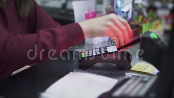 女性手拿着一张信用卡在终端上视频的预览图