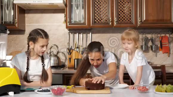 幸福的家庭妈妈和女儿们正在一起做生日蛋糕视频的预览图