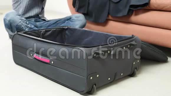 旅行行李和人的概念男人把衣服装进旅行袋视频的预览图
