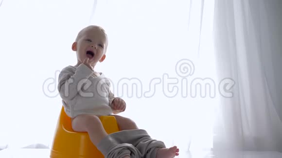 健康幼儿坐在明亮的房间里笑着上厕所的情绪快乐视频的预览图
