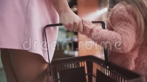 妈妈和小女儿一起在商场里的篮子的特写视频的预览图