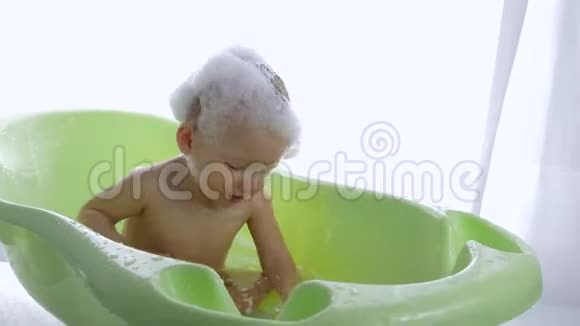 个人卫生干净的男孩与泡沫坐浴在明亮的房间视频的预览图
