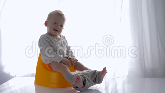 一个情绪激动的小男孩坐在房间里在明亮的房间里笑视频的预览图