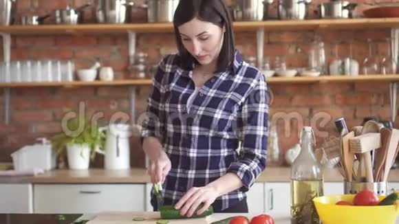 穿衬衫的女人在厨房里头痛得要命切蔬菜视频的预览图