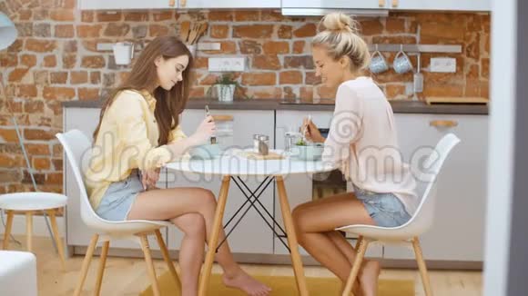 漂亮的女人在家吃沙拉和聊天视频的预览图