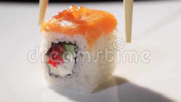 筷子在日本餐馆吃寿司特写镜头带有寿司的时尚白色盘子视频的预览图