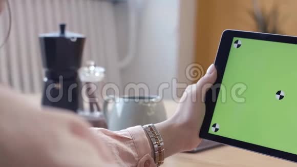 年轻女性穿着粉红色衬衫完美的指甲滑在她的平板电脑上的色度键绿色屏幕股票视频的预览图