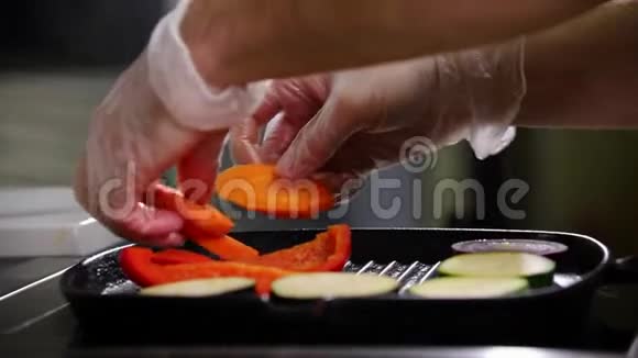 在厨房工作的厨师一个人把蔬菜放在锅里视频的预览图