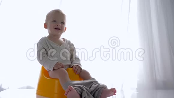 健康的童年情感愉悦的婴儿坐在明亮的房间里视频的预览图