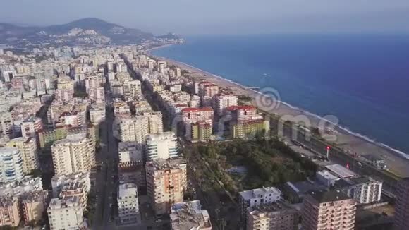 从海岸线上方可以看到土耳其阿拉尼亚的现代酒店沙滩和蓝色海水剪辑美丽美丽视频的预览图