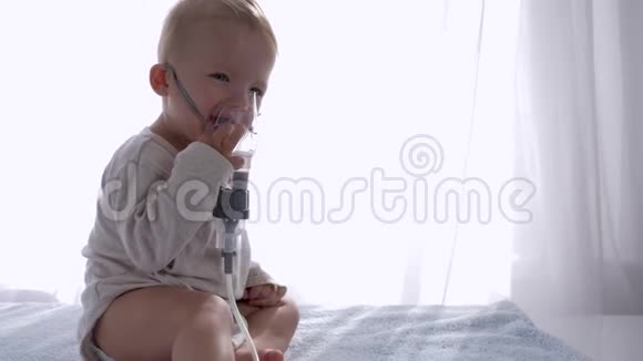 预防咳嗽可爱的婴儿通过吸入压缩机呼吸以治疗明亮房间的气道炎症视频的预览图