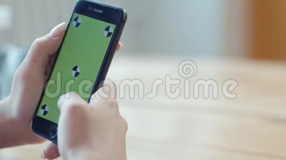 年轻的女人有漂亮的指甲手里拿着iPhone在彩色钥匙绿色屏幕上打字库存数据视频的预览图