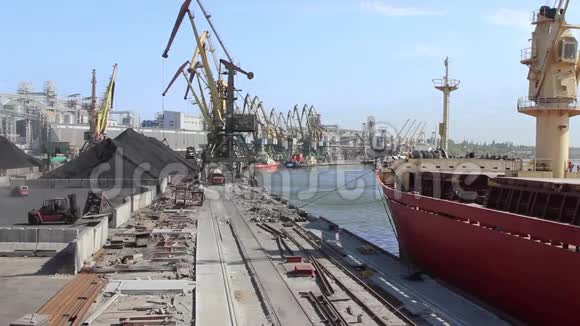 一艘大型货船停泊在港口码头等待散货海运视频的预览图