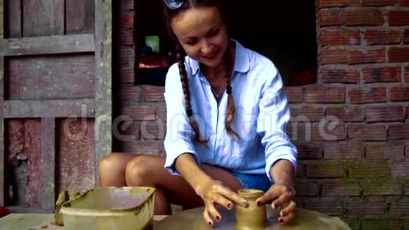 女孩的手指在旋转的陶轮上做粘土锅颈视频的预览图
