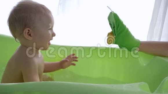 洗澡儿童父母手玩具在洗澡时招待小男孩视频的预览图