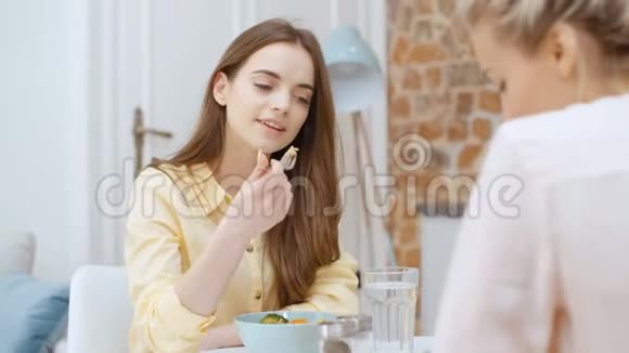 漂亮的女人在家吃沙拉和聊天视频的预览图