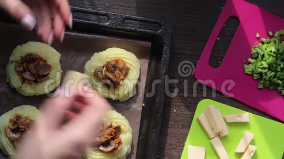 一个女人穿上蘑菇馅的奶酪一串串土豆泥躺在烤盘上在其他成分旁边视频的预览图