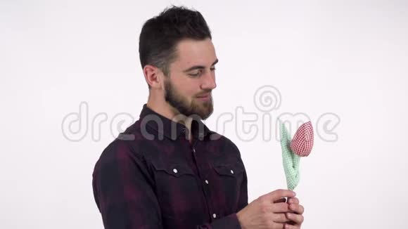 英俊的留胡子的浪漫男人把玩具花拿在相机上视频的预览图