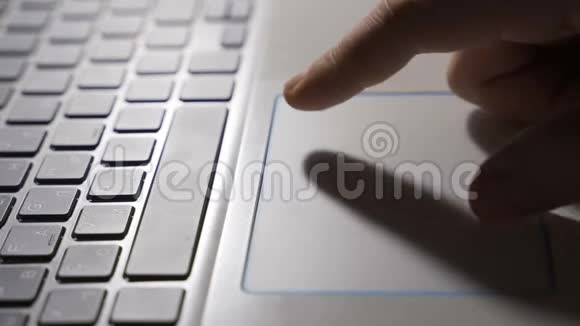 男人用笔记本电脑和笔记本电脑的触摸板浏览网页视频的预览图