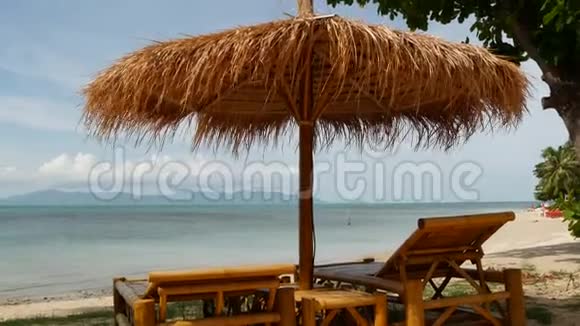 海面上的日落泰国海洋和天空背景上稻草和棕榈树的太阳伞放松放松视频的预览图