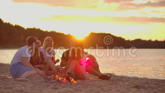 朋友们正在海滩上享受温暖的夏日夜晚视频的预览图