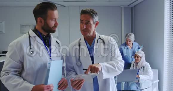 高加索男性医生在医院讨论数字平板电脑的正面看法视频的预览图