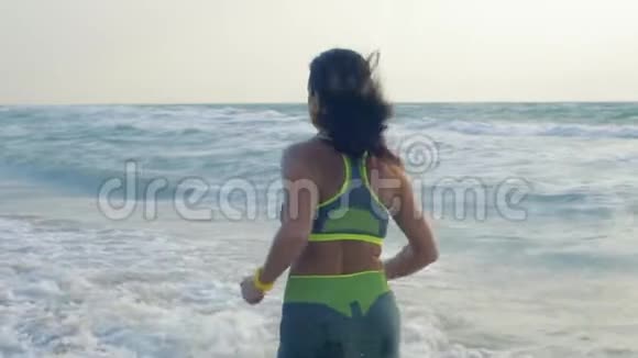 慢动作美丽的淡色女人在海上沙滩晨跑视频的预览图