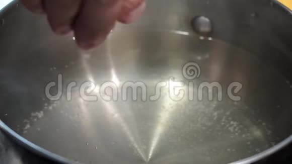 厨师的手在水的特写镜头上撒盐视频的预览图