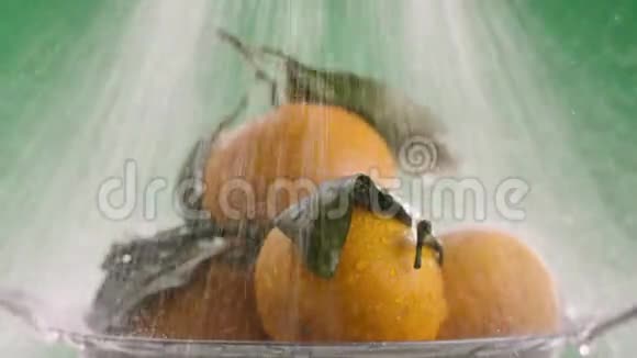 在橘子上注入强劲的水流在视频的末尾水停止了绿色的背景视频的预览图