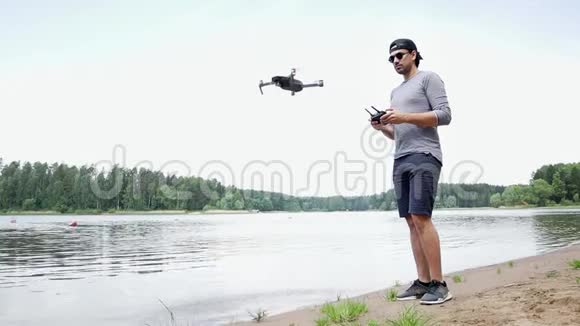 戴墨镜的年轻帅哥在看飞行无人机视频的预览图