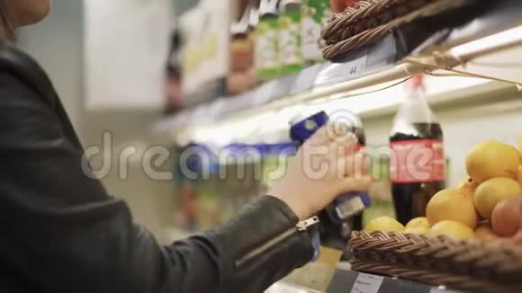 一个女孩从超市的架子上喝果汁然后离开视频的预览图