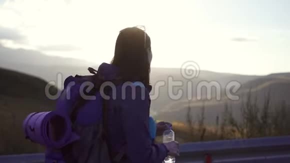 肖像女旅行者带着背包上路喝水视频的预览图