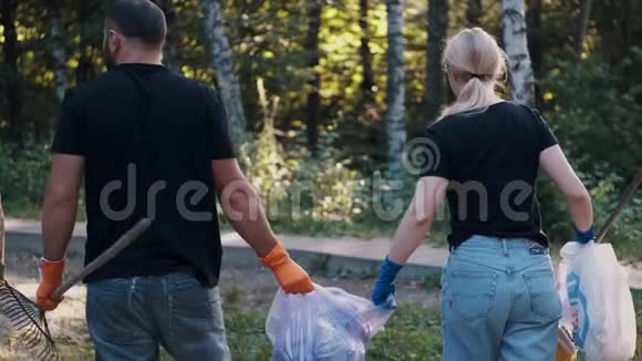 两名志愿者在清理森林后拿出垃圾和回收塑料瓶视频的预览图