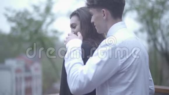 男人温柔地亲吻着站在她身后的女人年轻的夫妇在一起度过了爱情的时光视频的预览图