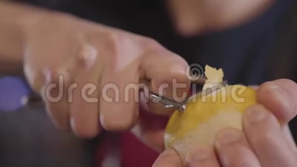 人手用特殊工具剥柠檬皮酒保切薄片水果做鸡尾酒视频的预览图