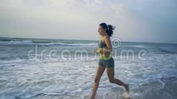美丽的女人从事健身在晨海沿岸做慢跑视频的预览图