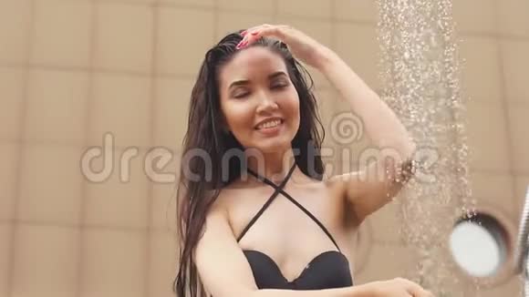夏天游泳池边穿着黑色泳衣的美丽少女洗澡视频的预览图