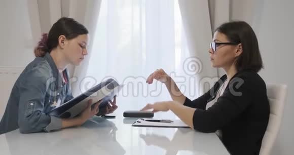 女专业心理治疗师心理学家与办公室少女交谈视频的预览图