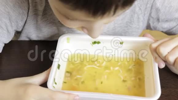 一个十几岁的白种人男孩在家吃中国快餐从一次性容器里的方便面视频的预览图